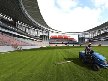 An employee cuts grass on the pitch of Ekaterinburg Arena, the stadium under construction which will host matches of the 2018 FIFA World Cup in the city of Yekaterinburg, Russia September 18, 2017. REUTERS/Stringer