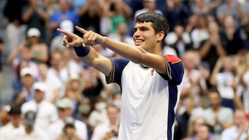 Carlos Alcaraz se&ntilde;ala a su zona t&eacute;cnica tras derrotar a Tsitsipas.