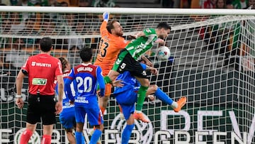 Real Betis' Spanish defender #05 Marc Bartra (R) goes for a header as Atletico Madrid's Slovenian goalkeeper #13 Jan Oblak defends during the Spanish league football match between Real Betis and Club Atletico de Madrid at the Cartuja Stadium in Seville on October 27, 2025. (Photo by CRISTINA QUICLER / AFP)