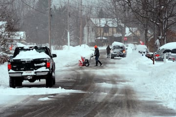 Los propietarios de viviendas comienzan la tarea de retirar la nieve intensa el 1 de diciembre de 2024 en Derby, Nueva York.