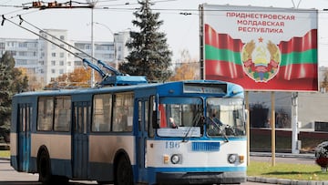 An old trolleybus rides near a poster with the official coat of arms in Tiraspol, in Moldova's self-proclaimed separatist Transdniestria, November 3, 2021.