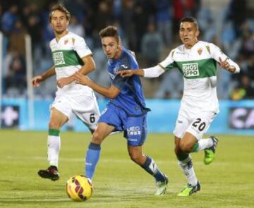 El centrocampista del Getafe Pablo Sarabia (c) controla el balón ante los jugadores del Elche, Pedro Mosquera (i) y el francés Faycal Fajr durante el partido correspondiente a la undécima jornada de Liga de Primera división que disputan en el estadio Coliseum Alfonso Pérez.
