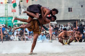 Dos luchadores compiten, ante la atenta mirada de un nutrido grupo de espectadores, durante un combate de Malakhra, una antigua forma de lucha que tiene su origen milenario en las regiones de Sindh (Pakistán) y Gujarat (India). La imagen corresponde a un torneo local celebrado en Karachi, la ciudad más poblada de Pakistán.