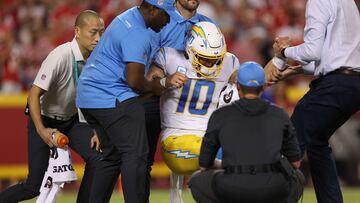 KANSAS CITY, MISSOURI - SEPTEMBER 15: Justin Herbert #10 of the Los Angeles Chargers is helped off the field by the medical staff after being hit during the fourth quarter against the Kansas City Chiefs at Arrowhead Stadium on September 15, 2022 in Kansas City, Missouri.   Jamie Squire/Getty Images/AFP