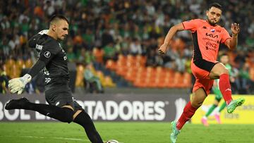 Atletico Nacional's goalkeeper Santiago Rojas (L) kicks the ball past Nacional's player Gustavo Caballero during the Copa Libertadores' second round second leg football match between Colombia's Atletico Nacional and Paraguay's Nacional at the Atanasio Girardot stadium in Medellin, Colombia, on February 28, 2024. (Photo by Jaime SALDARRIAGA / AFP)