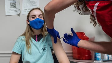 (FILES) In this file photo Audrey Vakker, 14, looks on as she get a Covid-19 vaccination at the Fairfax Government Center vaccination clinic in Fairfax, Virginia on May 13, 2021. - US health authorities said they were looking into a small number of report