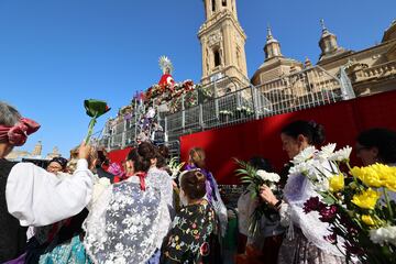 Varias personas durante la tradicional ofrenda de flores a la Virgen del Pilar.