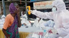 A health-worker wearing personal protective equipment (PPE) checks the temperature of a woman using an electric thermometer during a check-up campaign for the coronavirus disease (COVID-19), at a slum area in Mumbai, India June 29, 2020. REUTERS/Francis M