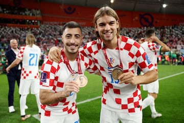 Los jugadores croatas Josip Juranovic y Borna Sosa mostrando sus medallas de bronce. 