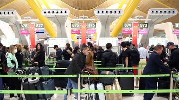 FILE PHOTO: Passengers wait for checking-in before boarding their flights to the U.S. at Madrid's Adolfo Suarez Barajas airport, Spain March 12, 2020. REUTERS/Sergio Perez/File Photo