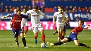 Sevilla's Argentinian midfielder Ever Banega (C) vies with Osasuna's Spanish midfielder Ruben Garcia (L) and Osasuna's Serbian midfielder Darko Brasanac (R) during the Spanish league football match between CA Osasuna and Sevilla FC at El Sadar stadium in