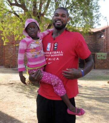 Amir Jonhson, jugador de los Toronto Raptors, llevando en brazos a una ni?a.