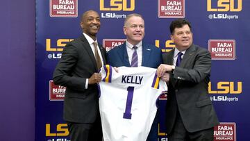 Dec 1, 2021; Baton Rouge, LA, USA; Newly named LSU Tigers head football coach Brian Kelly (middle) is presented with an LSU jersey by University president William F. Tate IV (left) and athletic director Scott Woodward( right) during a press conference at 