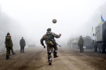 Soldados jugando al fútbol en pleno alto al fuego,rematando de cabeza.