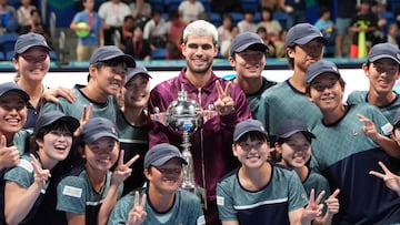 Carlos Alcaraz celebra la victoria en Tokio con los recogepelotas.