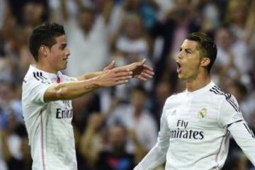 El delantero portugués del Real Madrid Cristiano Ronaldo (i) celebra con su compañero, el centrocampista colombiano James Rodríguez (d), el gol marcado de penalti al Atlético de Madrid, durante el partido de la tercera jornada de Liga de Primera División, disputado esta tarde en el estadio Santiago Bernabéu.