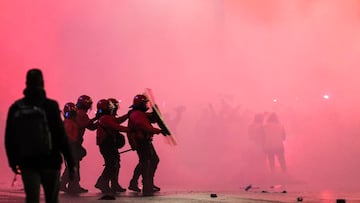 Varios agentes de la Ertzaintza se protegen ante el lanzamiento de objetos en la entrada del estadio San Mamés.