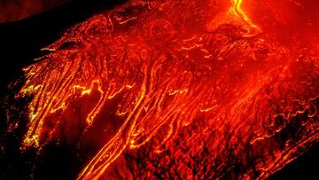 FILE PHOTO: Large streams of red hot lava flow as Mount Etna, Europe&#039;s most active volcano, continues to erupt, as seen from the village of Fornazzo, Italy February 23, 2021. REUTERS/Antonio Parrinello/File Photo