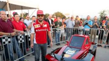 Fernando Alonso posa junto a un coche ecológico de Shell en un evento realizado por la marca en Estados Unidos.