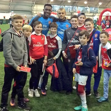 Welbeck y Wilshere junto a un grupo de niños.