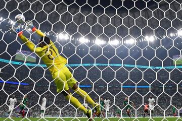 A freekick from Mexico's midfielder #24 Luis Chavez (not pictured) beats Saudi Arabia's goalkeeper #21 Mohammed Al-Owais (L) for Mexico's second goal during the Qatar 2022 World Cup Group C football match between Saudi Arabia and Mexico at the Lusail Stadium in Lusail, north of Doha on November 30, 2022. (Photo by Alfredo ESTRELLA / AFP) (Photo by ALFREDO ESTRELLA/AFP via Getty Images)