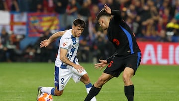 LEGANÉS (MADRID), 12/04/2025.- El lateral del Leganés Adrià Altimira (i) pelea un balón con Íñigo Martínez, del Barcelona, durante el partido de la jornada 31 de LaLiga EA Sports que CD Leganés y FC Barcelona disputan este sábado en el estadio de Butarque. EFE/Juan Carlos Hidalgo