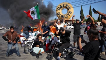 People hold Mexican flags and gesture next to a car in flames following multiple detentions by Immigration and Customs Enforcement (ICE), in the Los Angeles County city of Paramount, California, U.S., June 7, 2025. REUTERS/Daniel Cole TPX IMAGES OF THE DAY