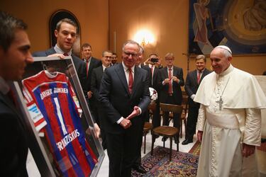 Karl-Heinz Rummenigge (en el centro), director ejecutivo del FC Bayern de Múnich, presenta un regalo con sus jugadores Manuel Neuer y Philipp Lahm para el Papa Francisco durante una audiencia privada en el Palacio del Vaticano el 22 de octubre de 2014 en la Ciudad del Vaticano, Vaticano.