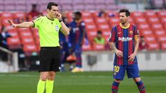 BARCELONA, SPAIN - OCTOBER 24: Lionel Messi of FC Barcelona confronts referee Referee Juan Martinez Munuera who uses his headset before awarding a penalty to Real Madrid following a VAR review during the La Liga Santander match between FC Barcelona and Re