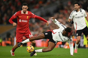 Liverpool's English defender #66 Trent Alexander-Arnold (L) vies with Fulham's Nigerian midfielder #17 Alex Iwobi (C) during the English Premier League football match