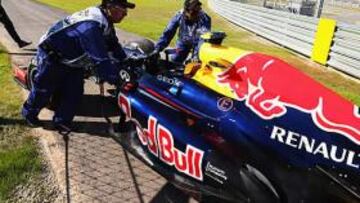 <b>RETIRADA. </b>Los comisarios empujan el coche de Webber.