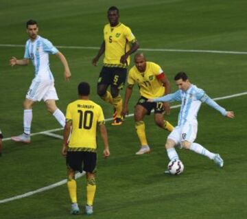 El delantero argentino Lionel Messi (d) dispara a puerta ante los jugadores jamaicanos Joel Joshua Frederick Melvin (i) y Rodolph William Austin (2d) durante el partido Argentina-Jamaica