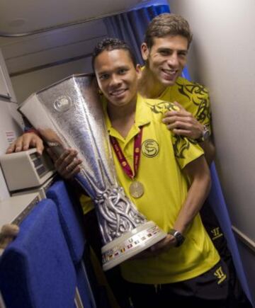 Bacca y Fazio con el trofeo en el avión.