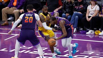 Kevin Durant, #35 of the Phoenix Suns, dribbles around a screen set by Jusuf Nurkic #20 on LeBron James #23 of the Los Angeles Lakers