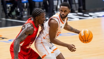 El base dominicano de Valencia Basket Jean Montero (d) controla el balón ante el base estadounidense de UCAM Murcia Dylan Ennis (i), durante el partido de la décimo primera jornada de la liga Endesa que están disputando este domingo en el Palacio de los Deportes de Murcia.