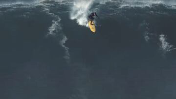 El surfista portugu&eacute;s Nic Von Rupp realizando el drop en una ola gigante con un neopreno con capucha y una tabla de surf amarilla en Nazar&eacute; (Portugal) el 9 de diciembre del 2021. 