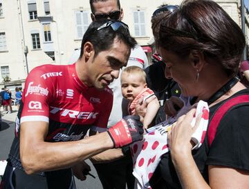 Alberto Contador firma un maillot a unos seguidores antes del comienzo de la etapa. 