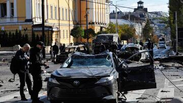 EDITORS NOTE: Graphic content / Police experts examine a car destroyed after a missile strike on the center of Ukrainian capital of Kyiv on October 10, 2022. - The head of the Ukrainian military said that Russian forces launched at least 75 missiles at Ukraine on October 10, 2022, with fatal strikes targeting the capital Kyiv, and cities in the south and west. (Photo by SERGEI CHUZAVKOV / AFP) (Photo by SERGEI CHUZAVKOV/AFP via Getty Images)