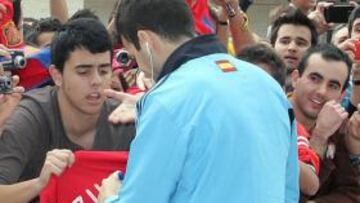 Cesc firma en una camiseta del Real Madrid.