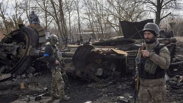 Ukranian servicemen walk past the wreck of a Russian tank in the village of Lukyanivka outside Kyiv, as Russia&#039;s invasion of Ukraine continues.