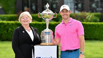 La presidenta de Golf Canadá Liz Hoffman y el golfista norirlandés Rory McIlroy posan con el trofeo de campeón del Canadian Open.