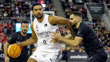 GRANADA 22/11/2025.- El ala pívot canadiense del Real Madrid, Trey Lyles (c) intenta superar al alero montenegrino del Covirán Granada Jovan Kljajic (d) durante el partido de Liga Endesa de baloncesto que se disputa este sábado en el Palacio de los Deportes de Granada. EFE/Pepe Torres.