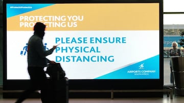 A passenger walks past a social distancing sign at Cape Town International Airport, run by state-controlled airports company ACSA, during the coronavirus disease (COVID-19) outbreak in Cape Town, South Africa, July 7, 2020. Picture taken July 7, 2020. REU