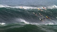 Webcam de Surfline capta surfistas en Waimea Bay remando olas gigantes. 