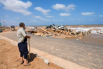 Un hombre observa los daños en la costa de Derna.