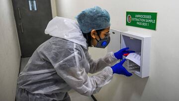 A laboratory staff wearing Personal Protective Equipments (PPE) receives samples collected for Covid-19 coronavirus testing as part of Project Ummeed, a public-private initiative dealing with large scale Covid-19 RT-PCR tests available for low-income households, at the Metropolis Healthcare Ltd. diagnostic centre in Mumbai on September 16, 2020. - Coronavirus infections in India soared past five million on September 16, as a WHO envoy warned the pandemic was "still at the beginning". (Photo by INDRANIL MUKHERJEE / AFP)