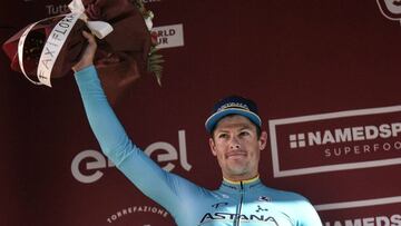 Denmark's Jakob Fuglsang celebrates on the podium after placing second of the one-day classic cycling race Strade Bianche (White Roads) on March 9, 2019 in Siena, Tuscany. (Photo by Marco BERTORELLO / AFP)