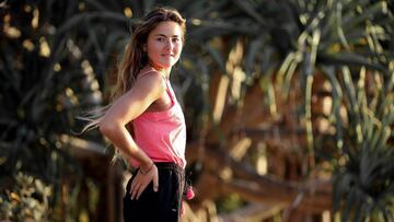 La surfista francesa Poeti Norac, vestida de calle con una camiseta rosa y unos pantalones negros.