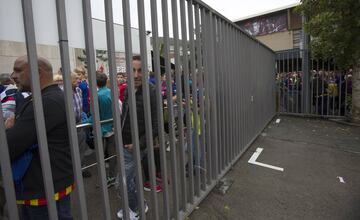 Un grupo de aficionados esperan en las puertas del recinto del Camp Nou.