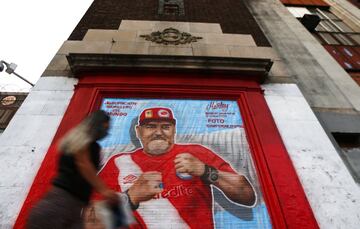 A woman walks past a mural of Diego Maradona in Buenos Aires, Argentina.